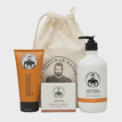 Set of Aussie Man Hands grooming products including a tube, soap bar, and bottle on a white background.